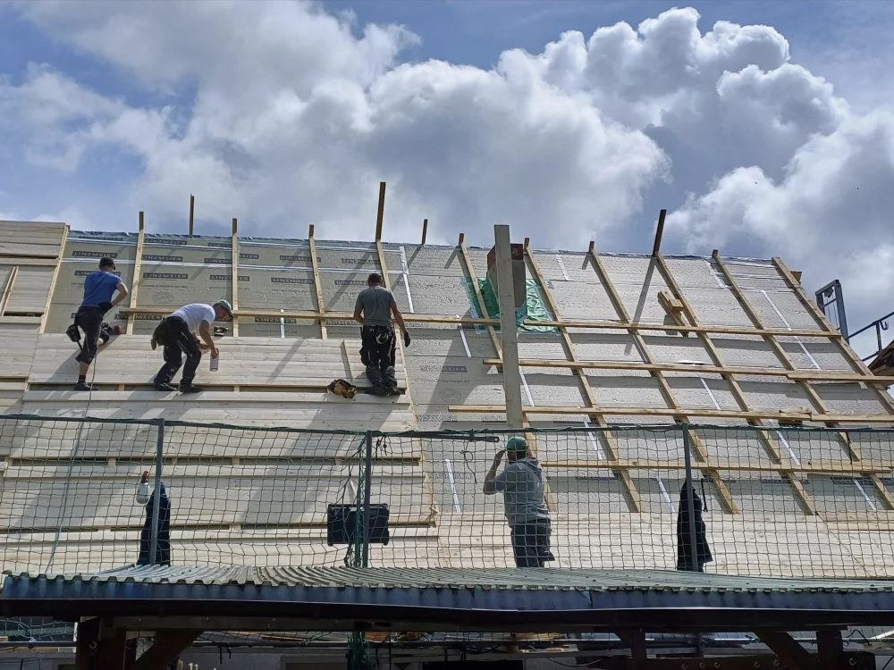 Dachdeckerarbeiten an Steildach mit Holzunterkonstruktion, Dämmung und Lattung für Neueindeckung im Rahmen von Dachsanierung oder Neubau.