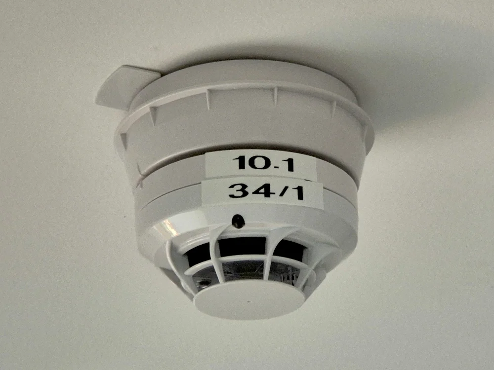 Deckenmontierter Rauchmelder im Innenbereich eines Gebäudes, moderne Brandschutztechnik zur frühzeitigen Raucherkennung und Sicherheit im Wohn- oder Gewerbebau.