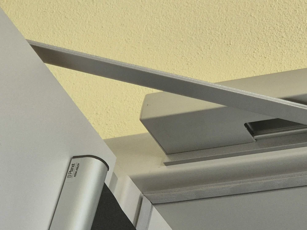 Automatische Brandschutztür mit Türschließer und Feststellanlage im Innenbereich, Teil moderner Sicherheits- und Brandschutztechnik in öffentlichen oder gewerblichen Gebäuden.