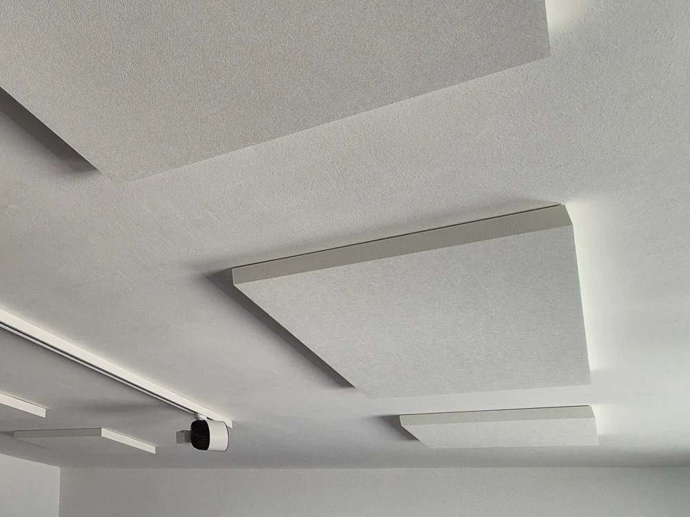 Moderne Akustikdecken-Elemente in schwebender Ausführung zur Schallabsorption im Innenraum, eingesetzt im Trockenbau für verbesserte Raumakustik und Design.