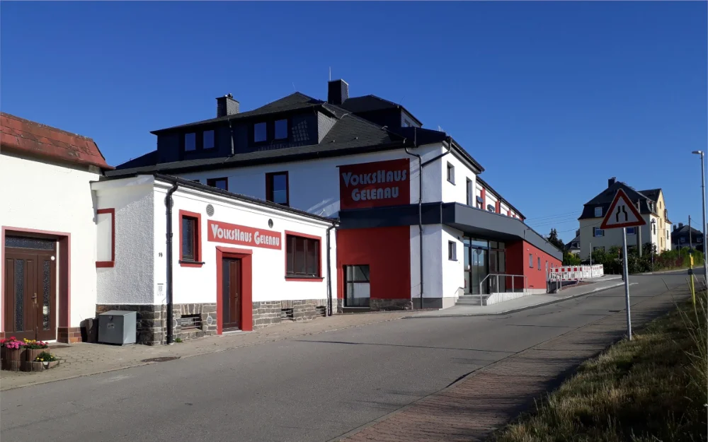 Modernisiertes Volkshaus Gelenau mit neu gestalteter Fassade, barrierefreiem Eingang und Außenbereich an Ortsstraße im ländlichen Raum.